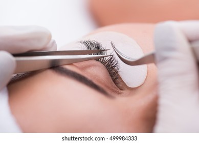 Beautiful young woman during eyelash extension