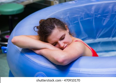 Beautiful Young Woman During Labour, Having Painful Cramps, Giving Birth In Water.