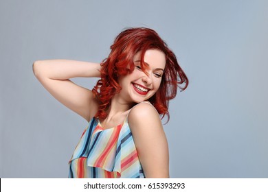 Beautiful young woman and dyed curly hair color background