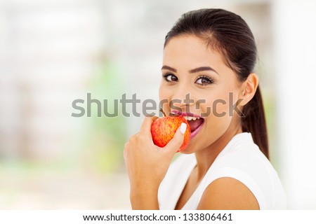 beautiful young woman eating an apple
