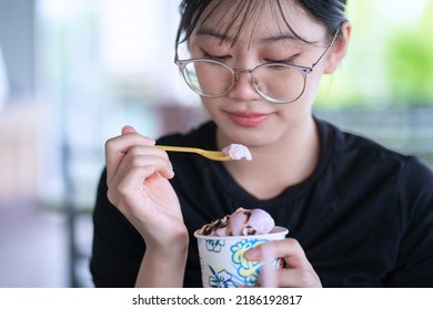 Beautiful Young Woman Eating Bowl Of Ice Cream.