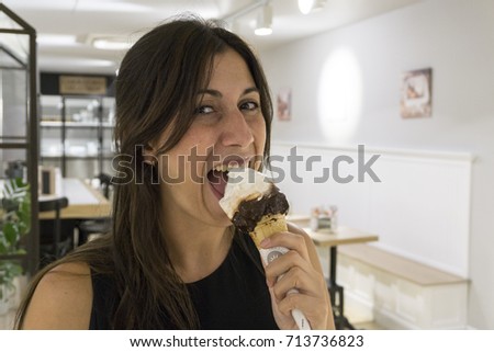 Beautiful young woman eating ice cream. satisfaction expression