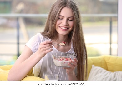 Beautiful Young Woman Eating Oat Flakes With Milk And Strawberries At Home