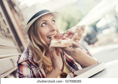 Beautiful Young Woman Eating A Slice Of Pizza In Cafe.