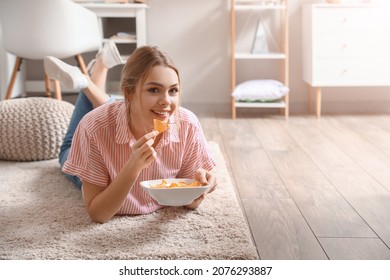 Beautiful young woman eating tasty nachos at home - Powered by Shutterstock