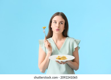 Beautiful Young Woman Eating Tasty Ravioli On Color Background