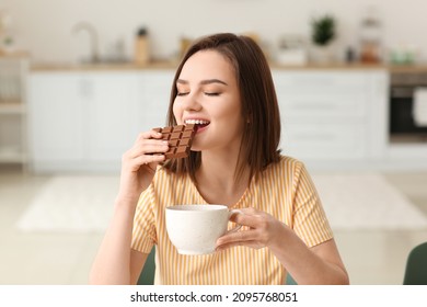 Beautiful young woman eating tasty chocolate at home - Powered by Shutterstock