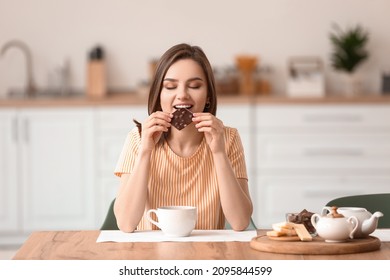 Beautiful Young Woman Eating Tasty Chocolate At Home