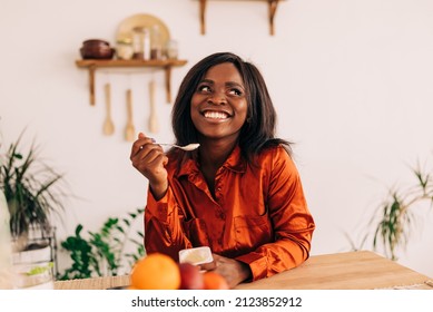 Beautiful young woman eating yogurt in the kitchen in the morning. Healthy food. Close up. Portrait shot - Powered by Shutterstock