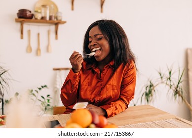 Beautiful Young Woman Eating Yogurt In The Kitchen In The Morning. Healthy Food. Close Up. Portrait Shot