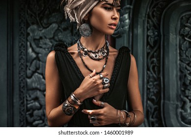 Beautiful Young Woman In Elegant Black Dress Wearing Turban. Oriental Princess