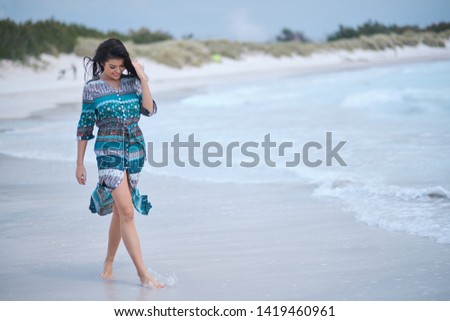 beautiful young woman in elegant dress on the beach 