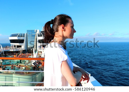 Beautiful young woman enjoying her vacation on a luxury cruise by the Brazilian coast. Wonderful time to appreciate the sun, sea and blue sky. Huge Italian ship in Brazil for summer holidays.