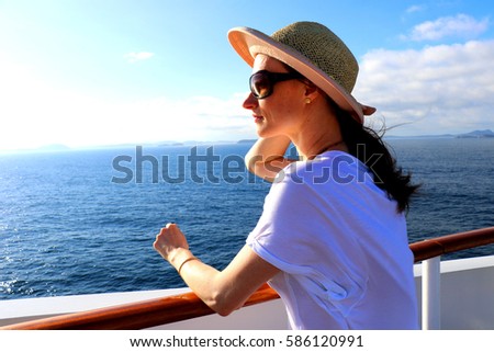 Beautiful young woman enjoying her vacation on a luxury cruise by the Brazilian coast. Wonderful time to appreciate the sun, sea and blue sky. Huge Italian ship in Brazil for summer holidays.