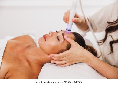 Beautiful young woman enjoying a hydrafacial treatment at the beauty salon. - Shutterstock ID 2199524299