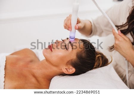 Beautiful young woman enjoying a hydrafacial treatment at the beauty salon. Stock fotó © 