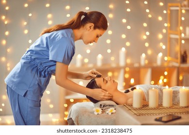 Beautiful young woman enjoying massage in spa salon. Side view portrait of beautician making face massage to relaxed female client. Facial beauty treatment, body care, wellness - Powered by Shutterstock