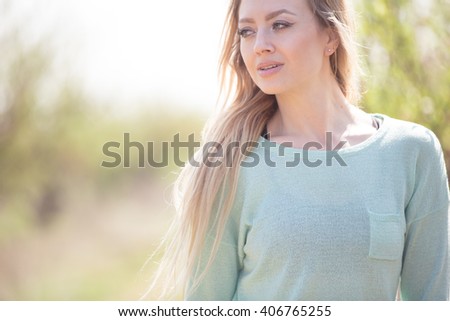 Beautiful young woman enjoying smell in a flowering garden