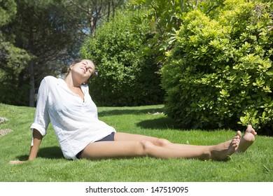beautiful young woman enjoying the sun on the meadow on a hot summer day