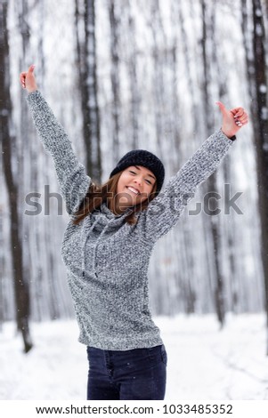 beautiful young woman enjoying winter in the woods