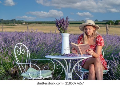 A Beautiful Young Woman Enjoys A Nice Summer Afternoon, And A Good Book In A Lavender Field.