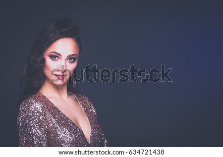 Beautiful young woman in evening dress on black background