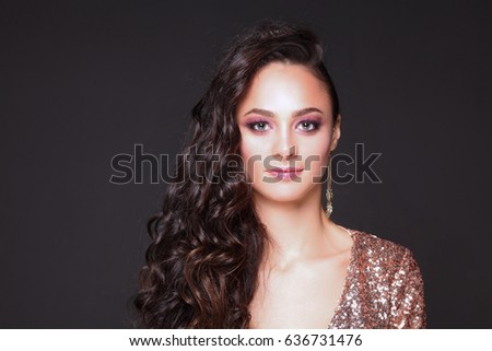 Beautiful young woman in evening dress on black background