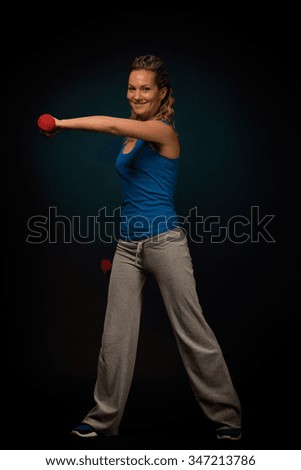 Similar – Close up front portrait of one young mid adult athletic woman in sportswear in gym over dark background, standing in boxing stance with hands and fists, looking at camera