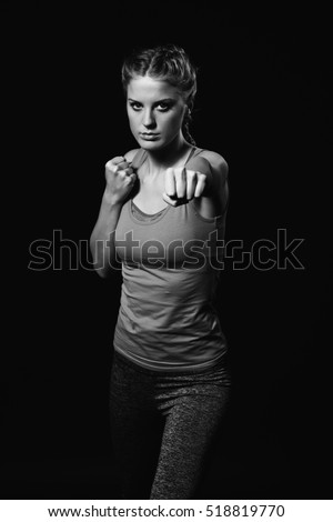 Similar – Close up front upper body portrait of one young athletic woman in sportswear in gym over dark background, looking at camera