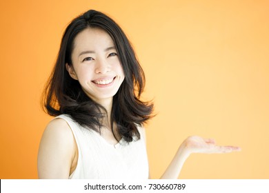 Beautiful Young Woman Explaining Against Orange Background