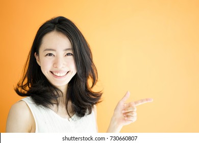 Beautiful Young Woman Explaining Against Orange Background