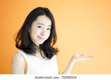 Beautiful Young Woman Explaining Against Orange Background