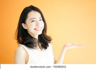 Beautiful Young Woman Explaining Against Orange Background