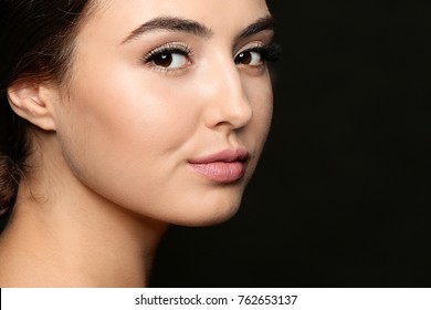 Beautiful Young Woman With Eyelash Extensions On Dark Background