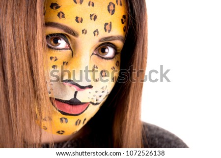 Beautiful young woman with face painted as a leopard