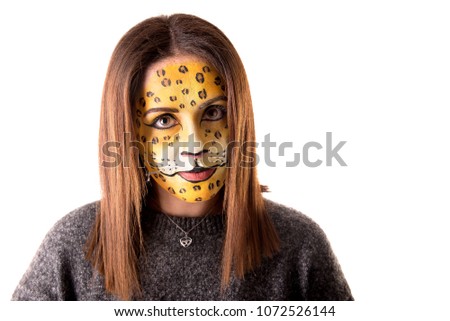 Beautiful young woman with face painted as a leopard