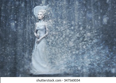Beautiful young woman. Fairy tale snow queen in silver dress and crown with staff in magic forest. Copy space.