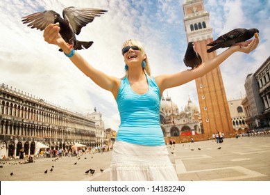 Beautiful young woman feeding pigeons