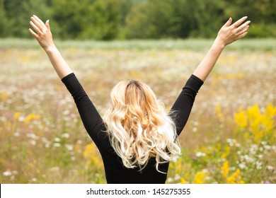 Beautiful Young Woman In A Field Of Flowers, Smiling And Having A Positive Attitude 