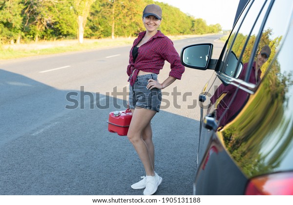 Beautiful young woman\
fixing the car on the roadside . Girl in shirt and jeans ready to\
repairing her car. woman mechanic . broken car on the road and\
woman waiting for\
help