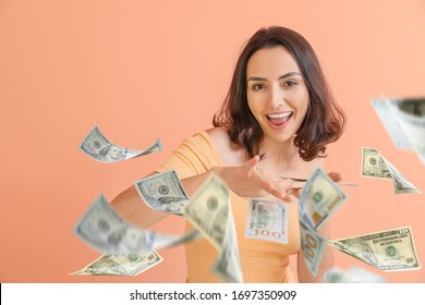 Beautiful young woman with flying money on color background