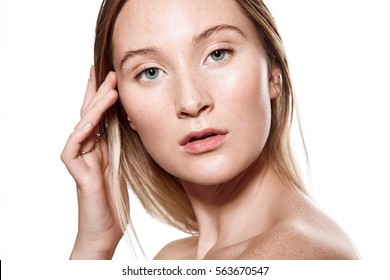 Beautiful Young Woman With Freckles On Her Face With A Light Sensitive Skin. Portrait With Bare Shoulders On A White Background