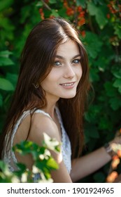 Beautiful Young Woman Gardening Outside In Summer Nature. Deeds And The Concept Of A Summer Outhouse, A Green Garden And Freedom