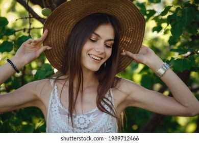 Beautiful Young Woman Gardening Outside In Summer Nature. Deeds And The Concept Of A Summer Outhouse, A Green Garden And Freedom