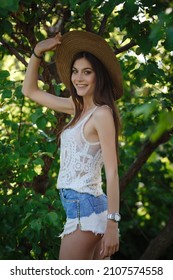 Beautiful Young Woman Gardening Outside In Summer Nature. Deeds And The Concept Of A Summer Outhouse, A Green Garden And Freedom