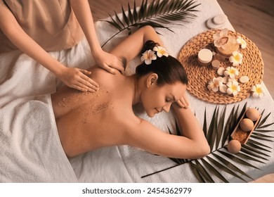 Beautiful young woman getting back scrub massage in spa salon - Powered by Shutterstock