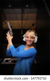 Beautiful Young Woman With The Gun On An Indoor Shooting Range