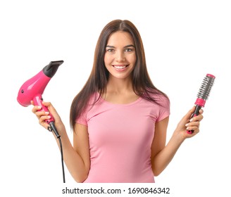 Beautiful young woman with hair dryer and brush on white background