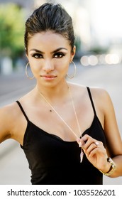 Beautiful Young Woman Hair Pulled Back Stylishly Posing Outdoors In Urban City Setting.