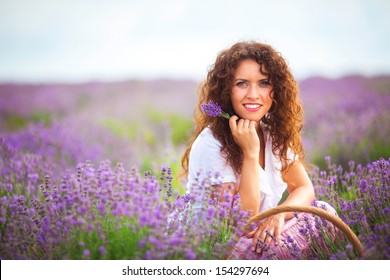 Beautiful young woman harvesting lavender